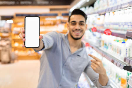 Male Showing Phone Screen Advertising Grocery Shopping Application In Supermarketの写真素材