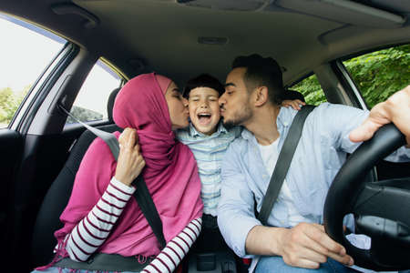 Auto Travel. Cheerful Muslim Family With Little Son Riding Car Togetherの写真素材