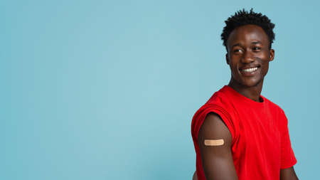 Coronavirus Vaccination Campaign. Portrait Of Black Guy With Adhesive Band On Armの写真素材
