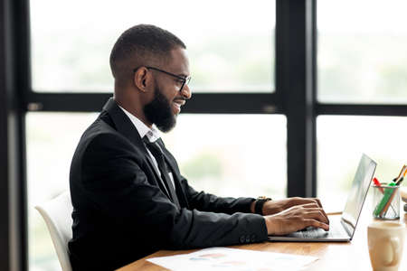 African American man using laptop typing on keyboardの写真素材