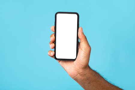Unrecognizable black man showing cellphone with mockup, advertising app or website, promoting online...