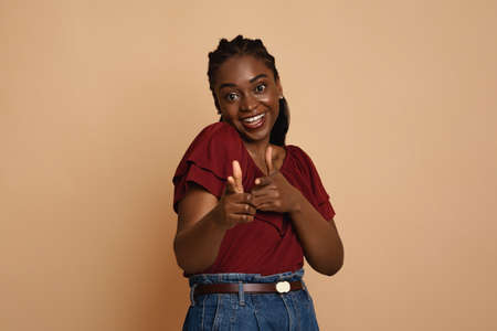 Positive african american young woman indicating at camera