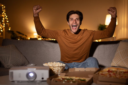 Emotional Guy Shaking Fists Watching Sport Channel Celebrating Victory Indoorの写真素材