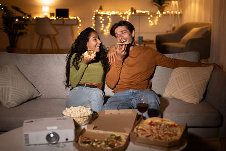 Couple Relaxing Eating Pizza Watching Movie Enjoying Weekend At Home