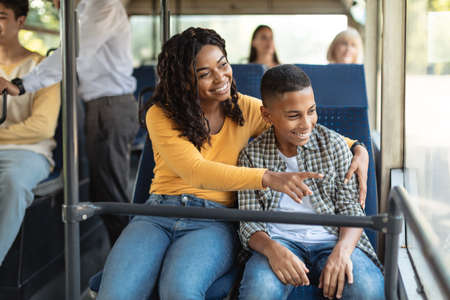 Loving smiling African American family going on a bus