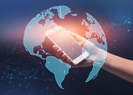 World Globe With Polygonal Dots Wireframe Over Female Hand Holding Smartphoneの写真素材