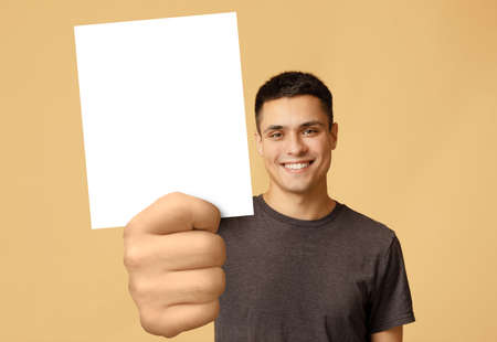 Handsome young man showing blank advertising card