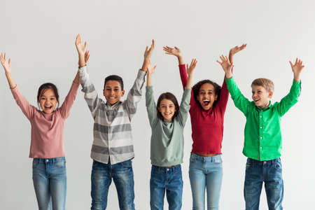 Joyful Kids Posing Raising Hands Shouting In Joy, Gray Backgroundの写真素材