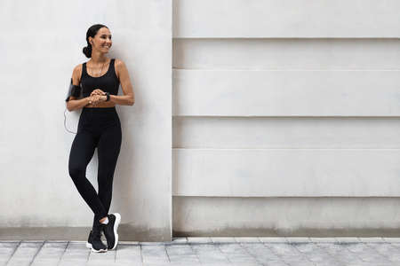 Fitness Ad. Athletic Lady In Stylish Sportswear Standing Outdoors Near Urban Wall