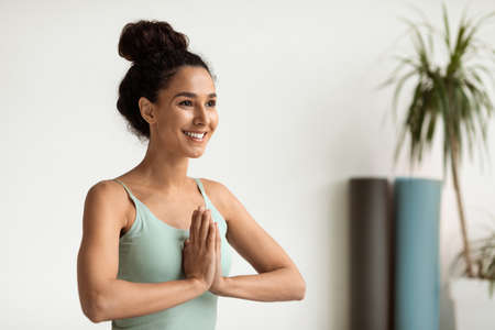 Namaste. Portrait Of Smiling Young Beautiful Woman Meditating At Homeの写真素材