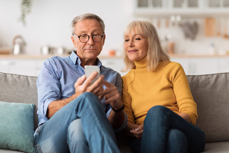 Senior Husband And Wife Using Smartphone At Home