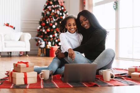 Portrait of happy black family using laptop on Xmas eveの写真素材