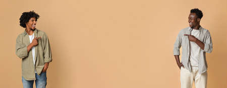 Check This. Two Cheerful Black Guys Pointing In Middle Of Beige Background