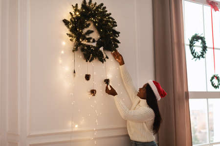 Portrait of happy black woman decorating flat for Xmasの写真素材