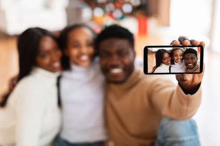 Happy African American family taking selfie on Xmasの写真素材