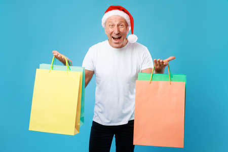 Excited man holding shopping bags at studio. Xmas Salesの写真素材