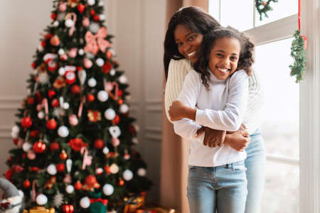 Happy black family celebrating Christmas and huggingの写真素材
