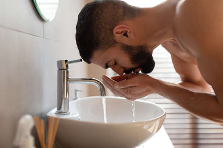Portrait of man washing his face at bathroomの写真素材