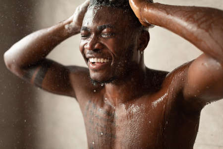 Black Male Taking Shower Washing Head With Eyes Closed Indoorの写真素材