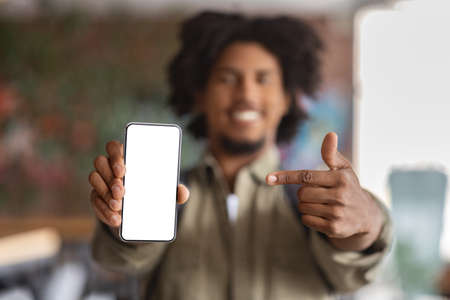 Check This. Closeup Shot Of Black Guy Pointing At Blank Smartphone Screenの写真素材