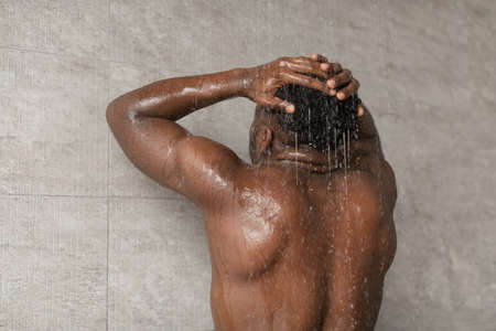 Unrecognizable African American Guy Taking Shower Washing Head At Homeの写真素材