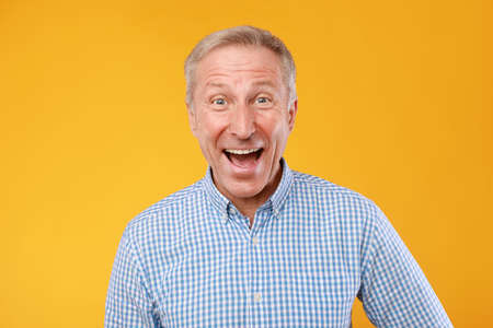 Portrait of happy mature man laughing posing at studio