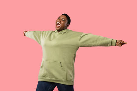 Cheerful Overweight African American Woman Shouting Spreading Hands, Pink Backgroundの写真素材