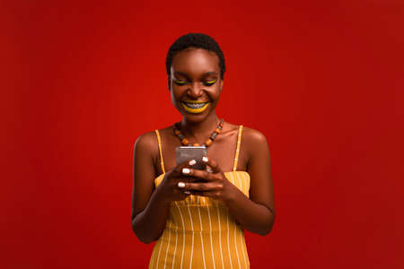 Positive stylish african american woman with cellphone, copy spaceの写真素材