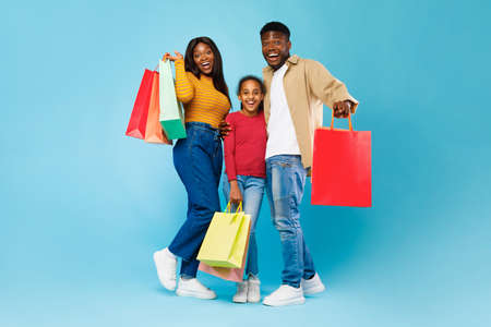 African American woman, man and girl posing with shopping bags