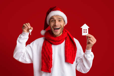 Cheerful Man In Santa Hat Holding Home Keys And Paper House Iconの写真素材