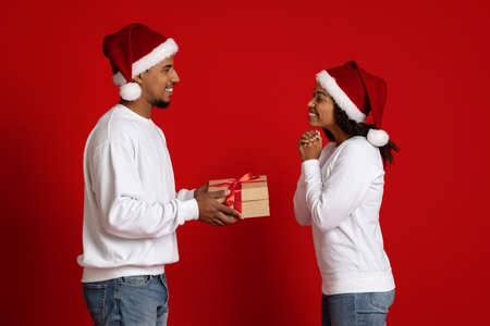Loving black guy giving xmas gift his excited girlfriendの写真素材