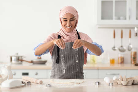 Islamic Lady In Hijab Baking In Kitchen, Sprinkle Flour On Rolled Doughの写真素材