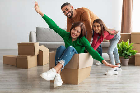 Happy family playing, celebrating relocation in new house