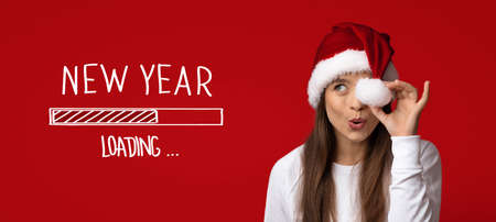 New Year Loading. Cheerful Woman In Santa Hat Covering Eye With Pompomの写真素材