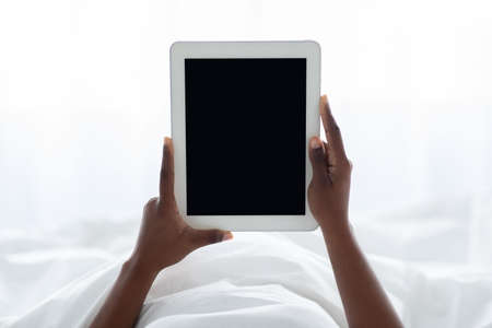 Female hands holding digital tablet with empty screenの写真素材