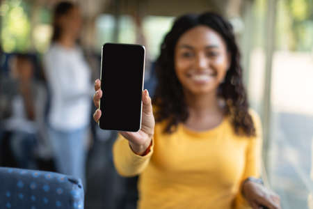 Young lady showing black empty smartphone screen, closeupの写真素材