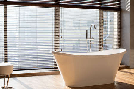 Empty bathroom with panoramic window in luxury apartmentの写真素材