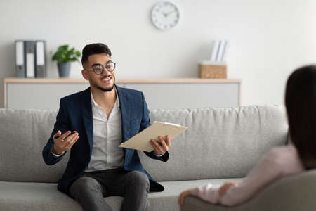 Psychotherapy consultation. Middle eastern counselor talking to patient on meeting at office, giving advice to clientの写真素材