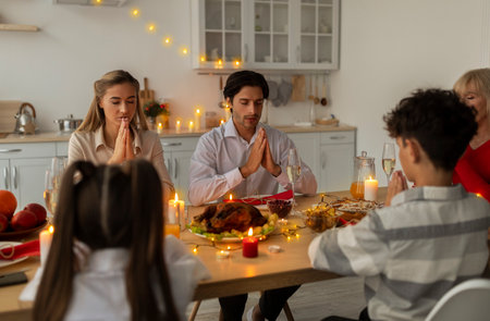 Big multi generation family praying at table before Christmas dinner at homeの写真素材