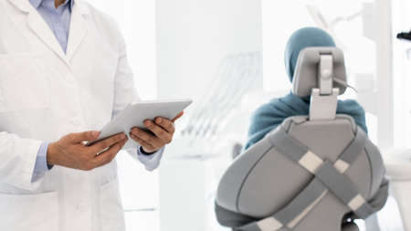 Technology And Healthcare. Dentist With Digital Tablet In Hands Standing In Cabinet