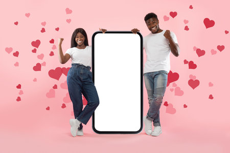 Couple showing white empty smartphone screen and making win gesture