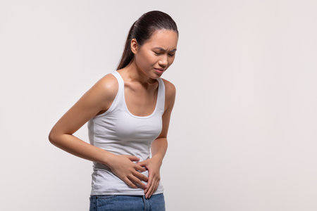 Sick chinese lady suffering from abdominal pain caused by diarrheaの写真素材