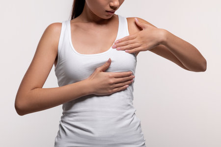 Unrecognizable young woman examining her breasts, closeupの写真素材