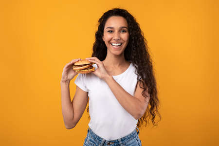 Funny Latin Lady Holding Burger At Studioの写真素材