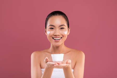 Happy korean woman showing her favorite beauty productの写真素材