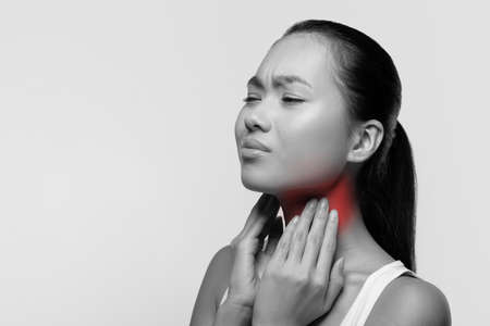 Black and white picture of young woman suffering from tonsillities