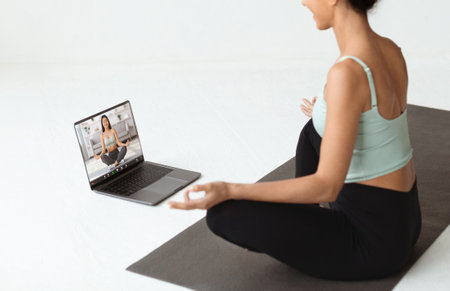 Virtual Yoga Class. Brunette Lady Meditating While Having Video Call With Instructorの写真素材