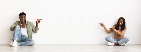 Positive black man and woman showing copy space between themの写真素材