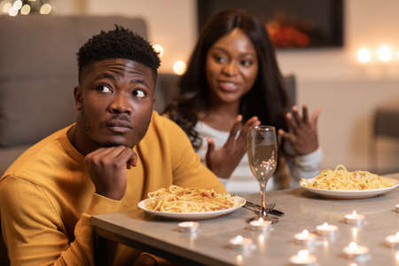 African Man Ignoring Girlfriend During Conversation Celebrating Valentine At Homeの写真素材