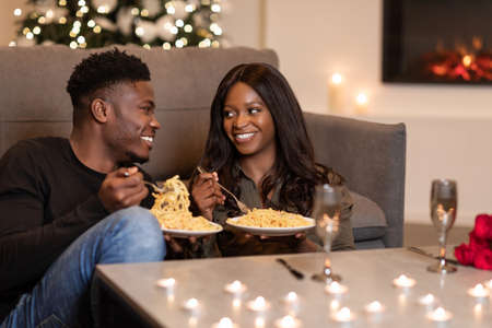 Happy Black Couple Eating Pasta Celebrating Valentines Day At Homeの写真素材